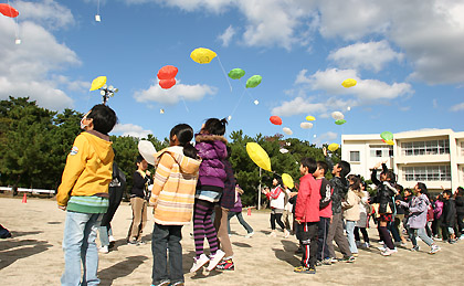 飛んでいくエコ風船に歓声をあげる西小学校の生徒