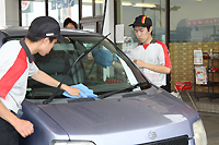 車の窓を拭く高校生