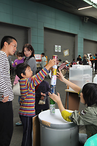 空き缶積みゲームに挑戦する子ども