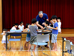 紙飛行機の作り方を習う