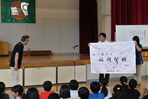 堅樹選手のお父様へ応援フラッグを託して