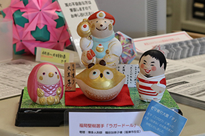これまでに寄贈していただいた干支の人形と古賀市出身の福岡堅樹選手のラガードールと一緒に玄関に飾っています